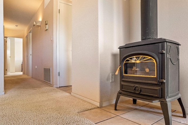 interior details with a wood stove and carpet floors