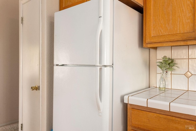 kitchen featuring tile countertops and white fridge