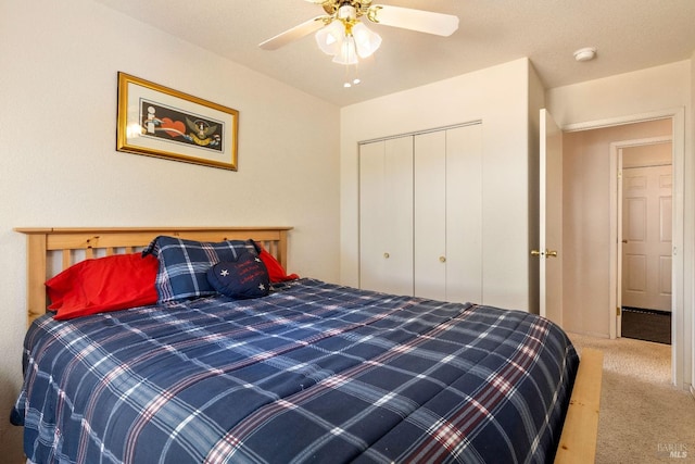 carpeted bedroom featuring ceiling fan and a closet