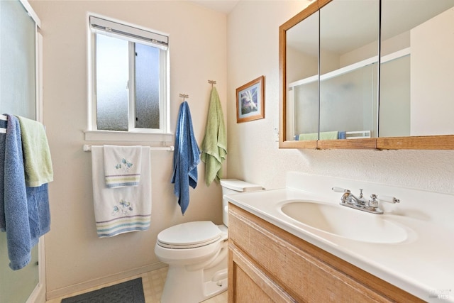 bathroom featuring vanity, toilet, and an enclosed shower