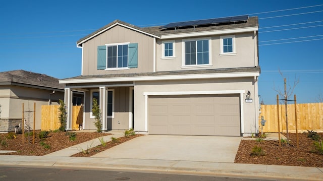 traditional-style house featuring board and batten siding, roof mounted solar panels, fence, and a garage