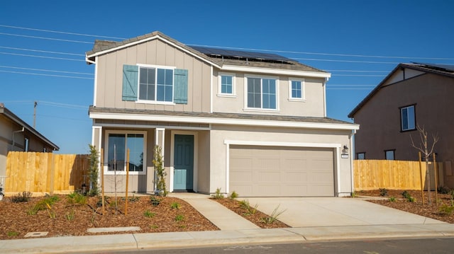 traditional home featuring an attached garage, solar panels, fence, concrete driveway, and board and batten siding