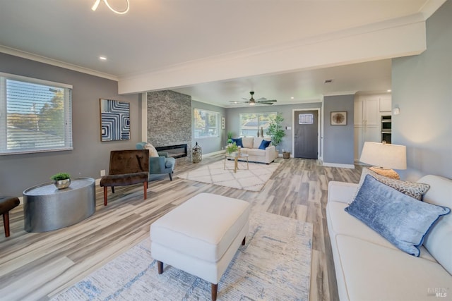 living room featuring a wealth of natural light, ceiling fan, light hardwood / wood-style floors, and ornamental molding