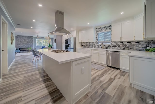 kitchen with island range hood, white cabinets, stainless steel appliances, and a kitchen island