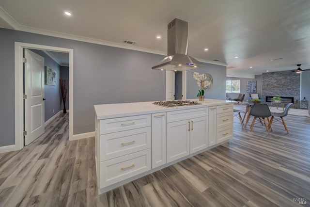 kitchen featuring crown molding, a kitchen island, light hardwood / wood-style floors, white cabinetry, and island exhaust hood