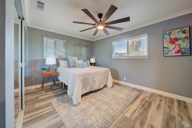 bedroom with multiple windows, ceiling fan, and light hardwood / wood-style flooring