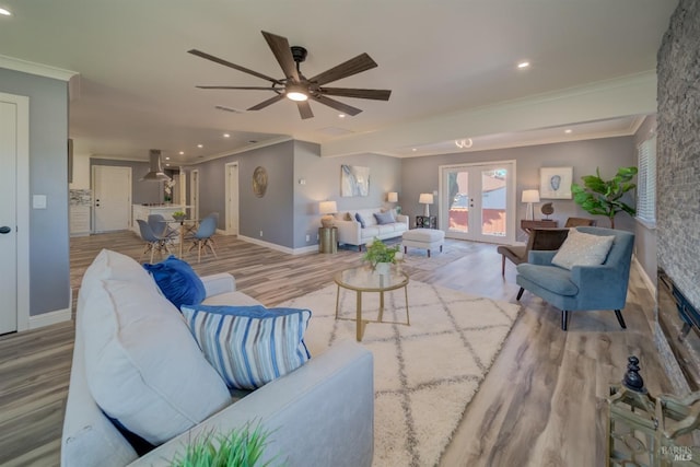 living room with french doors, light hardwood / wood-style flooring, ceiling fan, and ornamental molding