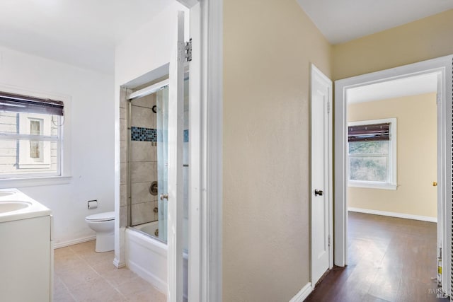 full bathroom featuring toilet, enclosed tub / shower combo, and vanity