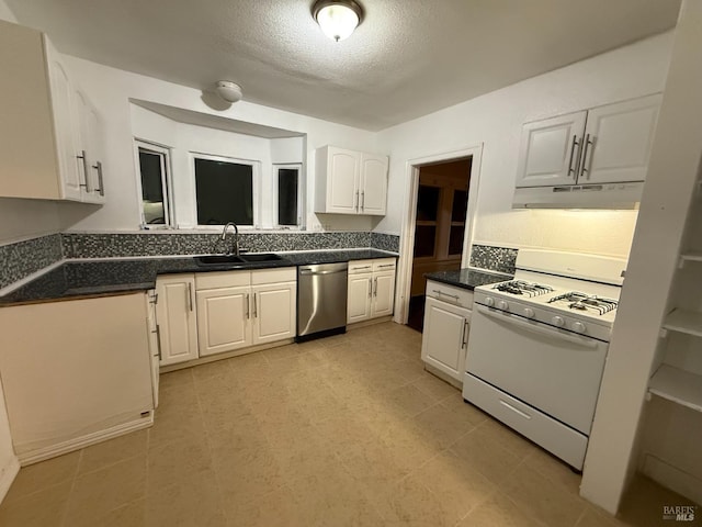 kitchen featuring stainless steel dishwasher, sink, white gas stove, a textured ceiling, and white cabinets