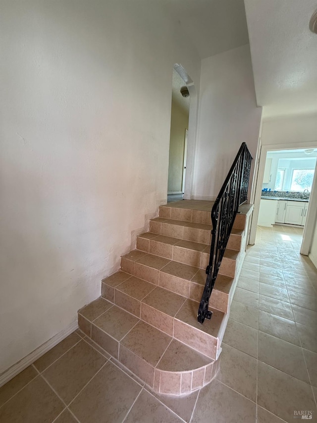 stairway with tile patterned floors