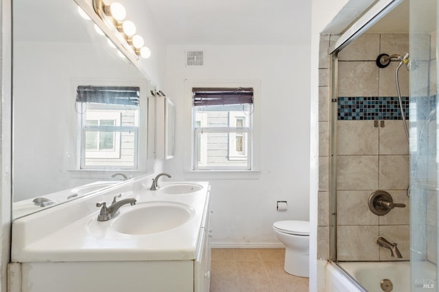 full bathroom with bath / shower combo with glass door, a wealth of natural light, tile patterned floors, and toilet