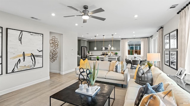 living room featuring ceiling fan and light wood-type flooring