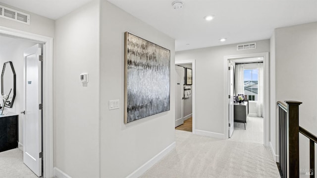 hallway featuring light colored carpet