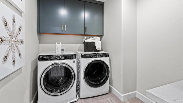 washroom featuring washer and dryer, light hardwood / wood-style flooring, and cabinets