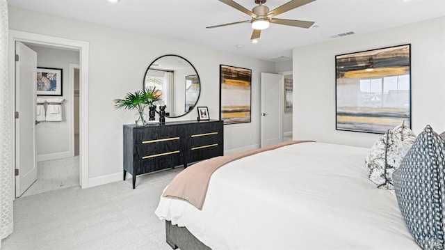 bedroom with ensuite bathroom, ceiling fan, and light colored carpet