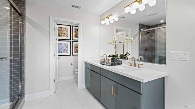 bathroom with tile patterned flooring, vanity, toilet, and an enclosed shower