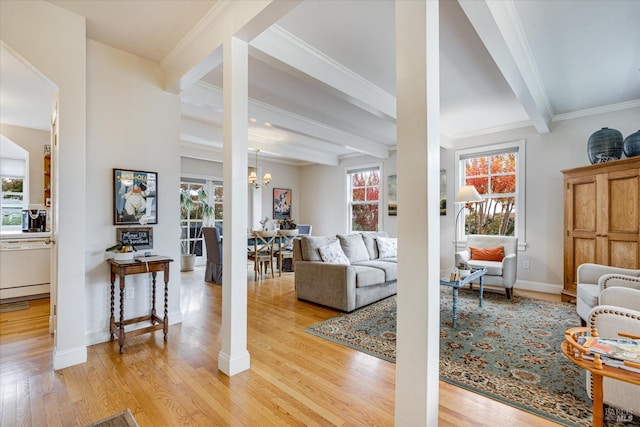 living room featuring ornate columns, crown molding, beam ceiling, a chandelier, and light hardwood / wood-style floors