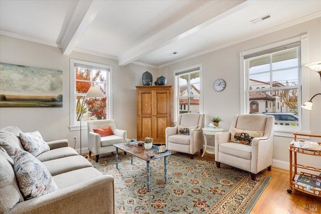 living room featuring beam ceiling, a wealth of natural light, light hardwood / wood-style flooring, and ornamental molding