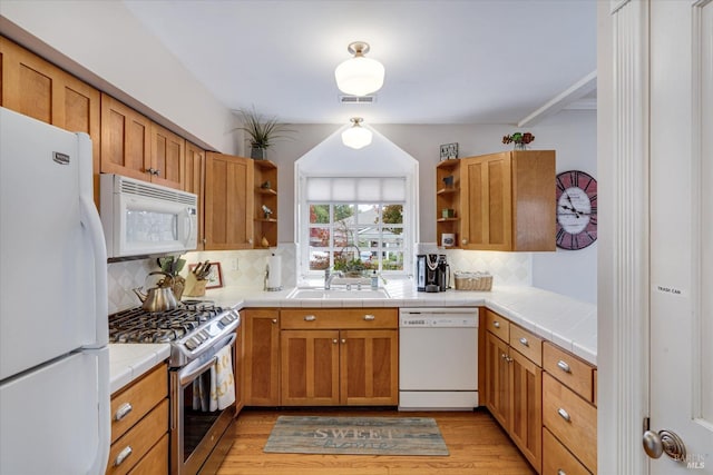 kitchen with tile countertops, light hardwood / wood-style floors, and white appliances