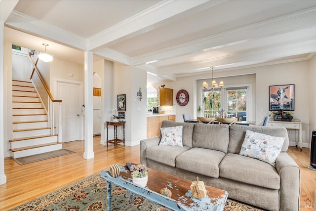 living room with hardwood / wood-style floors, an inviting chandelier, crown molding, and beam ceiling