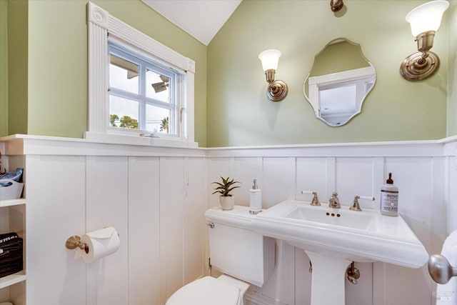 bathroom featuring toilet, lofted ceiling, and sink