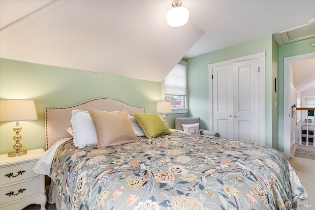 bedroom with carpet flooring, lofted ceiling, and a closet