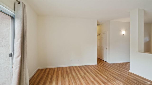 unfurnished room featuring light wood finished floors and baseboards