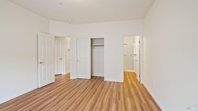 unfurnished bedroom featuring a closet, light wood-type flooring, and baseboards