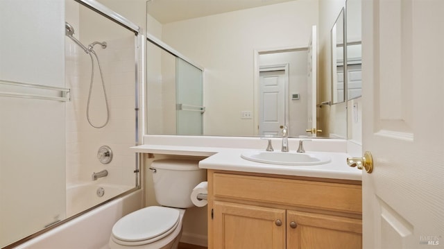 full bathroom featuring combined bath / shower with glass door, vanity, and toilet