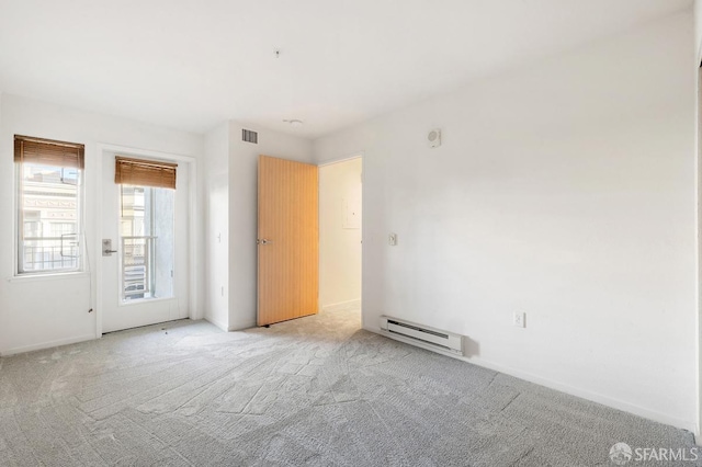 carpeted empty room featuring baseboard heating