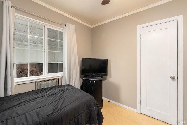 bedroom featuring light hardwood / wood-style flooring, ceiling fan, and crown molding