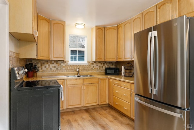 kitchen featuring electric range, stainless steel fridge, sink, and light brown cabinets