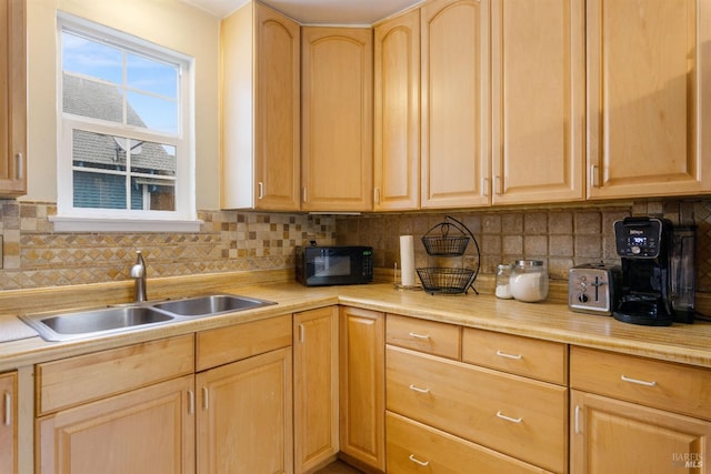 kitchen with decorative backsplash, light brown cabinetry, and sink