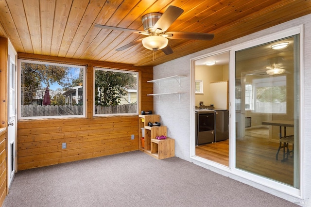 sunroom / solarium featuring washer and clothes dryer, ceiling fan, and wooden ceiling