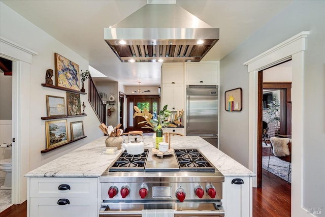 kitchen with white cabinets, high end appliances, island exhaust hood, and light stone countertops