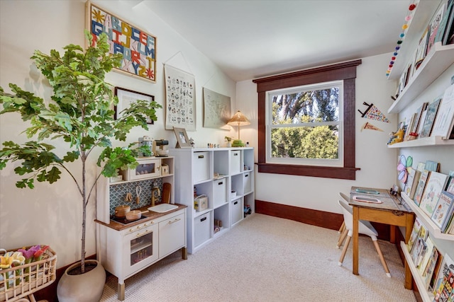 recreation room with light colored carpet