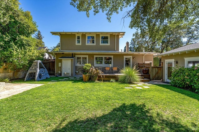 rear view of house with a lawn and a deck