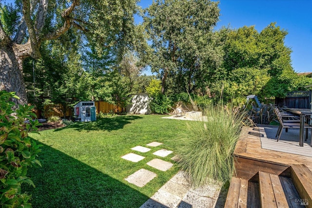 view of yard featuring a deck and a shed