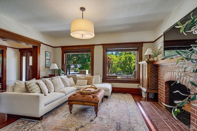 living room featuring a brick fireplace and hardwood / wood-style floors