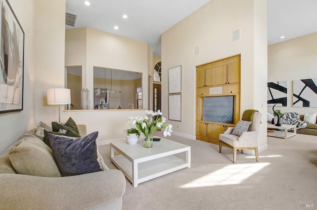 living room with recessed lighting, visible vents, carpet floors, and a high ceiling