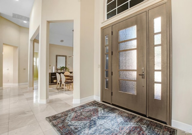 entrance foyer with a high ceiling, baseboards, and visible vents