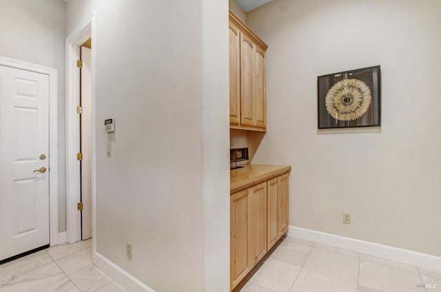 hallway with light tile patterned floors and baseboards