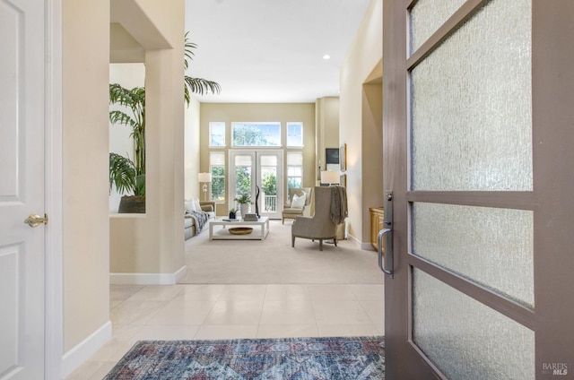 interior space featuring tile patterned flooring, carpet, french doors, and baseboards