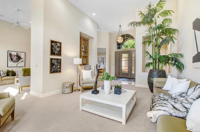 carpeted living area with recessed lighting, baseboards, and a towering ceiling