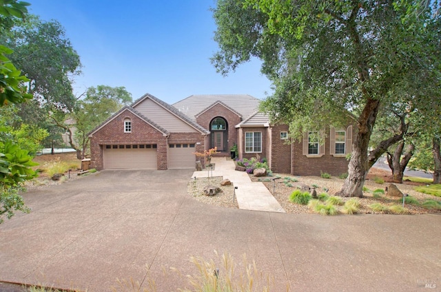 view of front of house featuring a garage, brick siding, and aphalt driveway