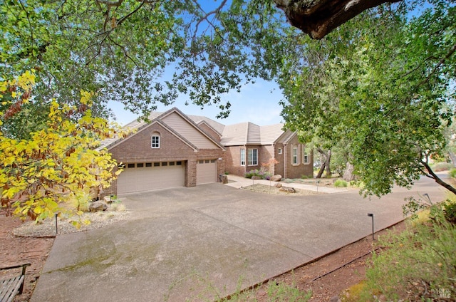 view of front of house featuring brick siding, a garage, and driveway