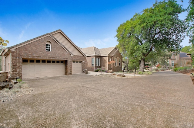 view of front of home featuring brick siding, concrete driveway, and a tiled roof