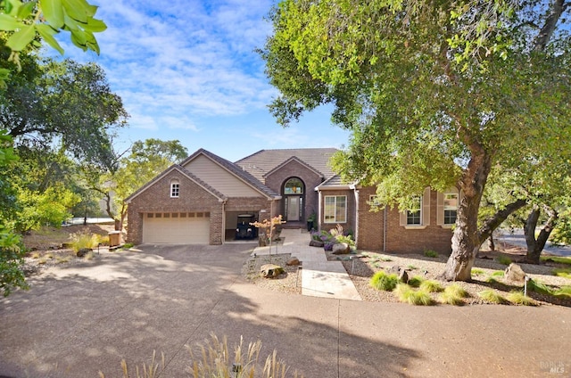 view of front facade featuring aphalt driveway, brick siding, and an attached garage