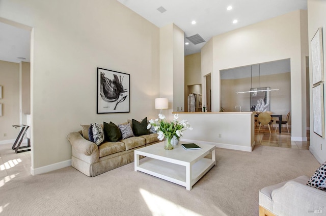 living area featuring recessed lighting, baseboards, carpet, and a towering ceiling