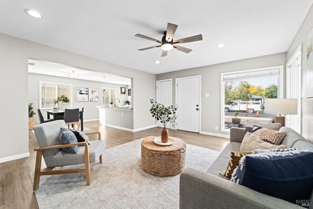 living room with hardwood / wood-style flooring, ceiling fan, and sink